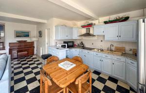 a kitchen with white cabinets and a wooden table at Maison Vue Mer in Quiberville