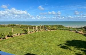 a large lawn with the ocean in the background at Maison Vue Mer in Quiberville +14 photos
