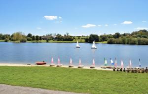 a group of sailboats on a lake with people at Belle Maison À Colombages in La Baroche-sous-Lucé