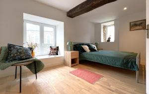 a bedroom with a green bed and a window at Belle Maison À Colombages in La Baroche-sous-Lucé