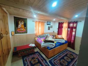 a small room with a bed and two rugs at Gremuspa Homestay in Kyelang