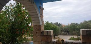 an archway with a view of a garden with trees at Eco wellness the arch in Lévktron