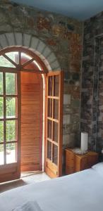 a bedroom with a wooden door and a window at Eco wellness the arch in Lévktron