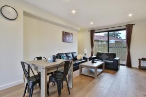 a living room with a table and a couch at Quality Apartments Dandenong in Dandenong