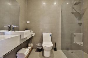 a bathroom with a toilet and a sink and a shower at Quality Apartments Dandenong in Dandenong +4 photos
