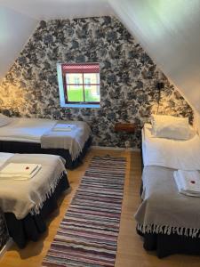 ein Dachzimmer mit zwei Betten und einem Fenster in der Unterkunft Peppinge Bed & Breakfast in Löderup
