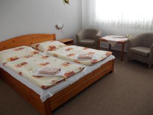 a bedroom with a bed with two chairs and two tables at Hotel Milotel in Olomouc