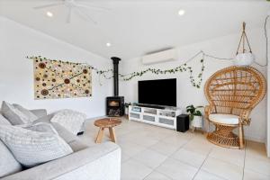 a living room with a couch and a tv at Tallows Coastal Retreat in Kingscliff