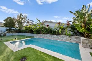 a swimming pool in the backyard of a house at Tallows Coastal Retreat in Kingscliff