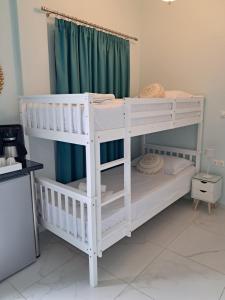 two bunk beds in a room with green curtains at MANI HOLIDAYS Rooms in Neo Itilo