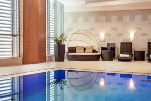 ein Wohnzimmer mit Bett und Swimmingpool in der Unterkunft DoubleTree by Hilton Bratislava in Bratislava