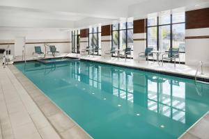 a swimming pool with blue water in a building at Hampton Inn & Suites Detroit/Troy in Clawson