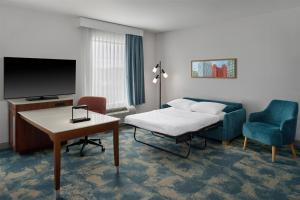 a hotel room with a bed and a tv and a chair at Hampton Inn & Suites Detroit/Troy in Clawson