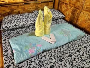 a pair of yellow shoes and a book on a bed at Itawis Resort - Nature Chalet in Silang