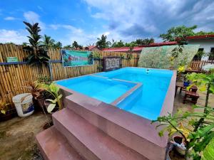 a swimming pool in a yard next to a fence at Itawis Resort - Nature Chalet in Silang