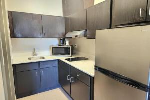 a small kitchen with a refrigerator and a microwave at Days Inn & Suites by Wyndham Katy in Katy