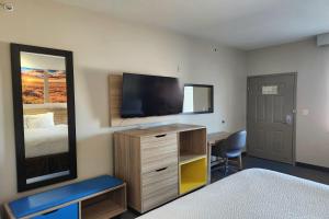 a bedroom with a bed and a desk and a mirror at Days Inn & Suites by Wyndham Katy in Katy +19 photos