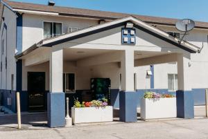 a building with two flower pots in front of it at Travelodge by Wyndham Worland in Worland