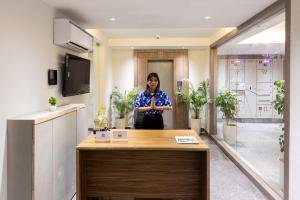 a woman standing behind a counter in an office at Alaya Stays Luxora Suites, Golf Course Rd near galleria in Gurgaon +48 photos