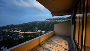 a balcony with a view of a city at Aloche Apartments in Murree