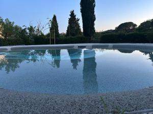 a swimming pool with its reflection in the water at Ca 18 rooms in Lucignano