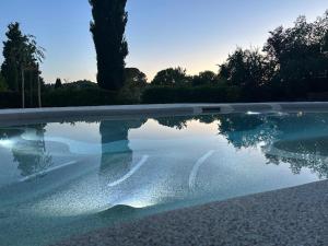 a swimming pool with its reflection in the water at Ca 18 rooms in Lucignano +16 photos