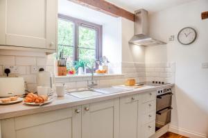 a kitchen with white cabinets and a sink and a window at 2 Bed in Carmel oc-wai210 in Llanerchymedd +19 photos