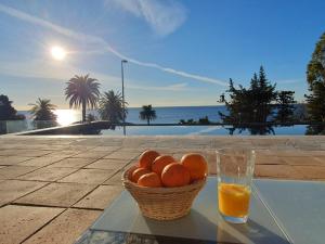 a basket of oranges and a glass of orange juice at Villa Naussica in Saint-Raphaël