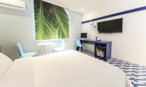 a hotel room with a bed and a desk and a tv at Hotel Yeogiuhtte Chungjangro in Gwangju