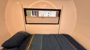 a bed in a small room with a window at La caravane de Camille & Piscine in Soulaires +5 photos