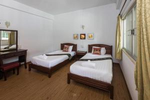 a room with two beds and a piano at Miami Hotel in Chiang Mai