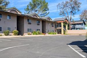 a large parking lot in front of a hotel at Olive Tree Inn & Suites, a Howard Johnson by Wyndham in San Luis Obispo