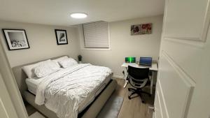 a bedroom with a bed and a desk with a laptop at Comfy-home in YYC