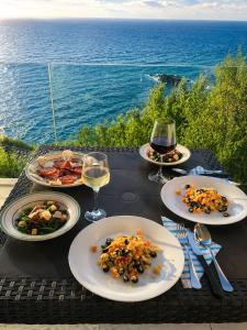 a table with plates of food and glasses of wine at Feli's Apartment in Castelsardo