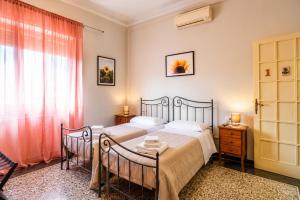 a bedroom with two beds and a window at Villa Catelli in Lucca