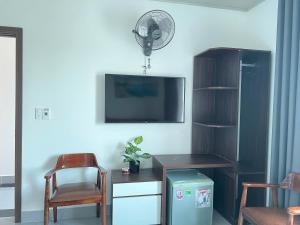 a living room with a tv and a desk and a chair at Hải An Hotel in Nhượng Bạn +14 photos
