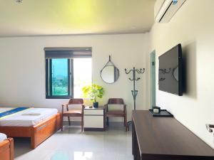 a bedroom with a bed and a desk and a tv at Hải An Hotel in Nhượng Bạn