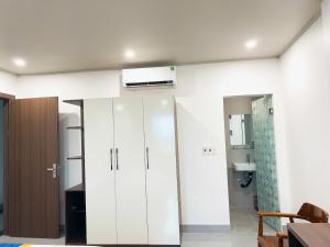 a bathroom with white cabinets and a air conditioner on the ceiling at Hải An Hotel in Nhượng Bạn