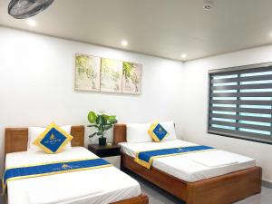 a bedroom with two beds and a window at Hải An Hotel in Nhượng Bạn