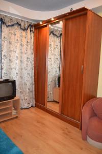 uma sala de estar com uma televisão e uma porta de vidro deslizante em Apartment on Peremogy Square em Kiev