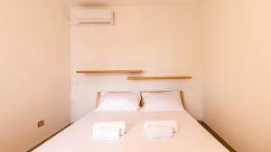 a bedroom with a bed with two towels on it at Golden Sunset - S'Archittu in S'archittu Cuglieri