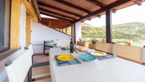 a table with two plates of food on it on a balcony at Golden Sunset - S'Archittu in S'archittu Cuglieri