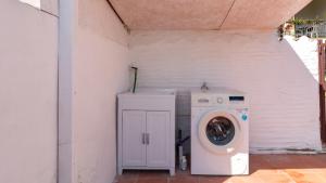 a washer and dryer in a small white room at Golden Sunset - S'Archittu in S'archittu Cuglieri