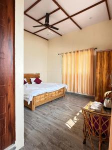 a bedroom with a bed and a ceiling fan at Mountain Vibe Resort in Chamba