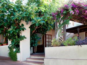 une entrée à un bâtiment avec des fleurs et des plantes dans l'établissement Hotel Corallo, à Pomonte