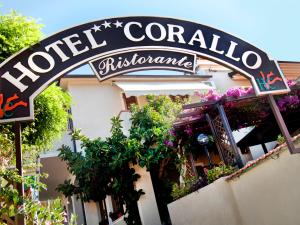 a sign on the side of a building with plants at Hotel Corallo in Pomonte
