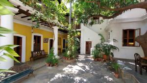 a courtyard of a house with trees and plants at Gratitude Heritage in Pondicherry