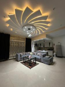a living room with couches and a large ceiling at Aloche Apartments in Murree