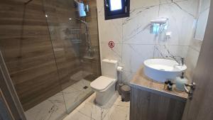 a bathroom with a shower and a toilet and a sink at Villa RELAX in Tsoukalades