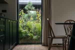 a door leading into a room with a garden outside at Chalets by Slow Tatry Boutique Resort&SPA in Zakopane
